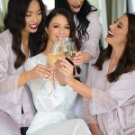 Bride celebrates with bridesmaids with champagne